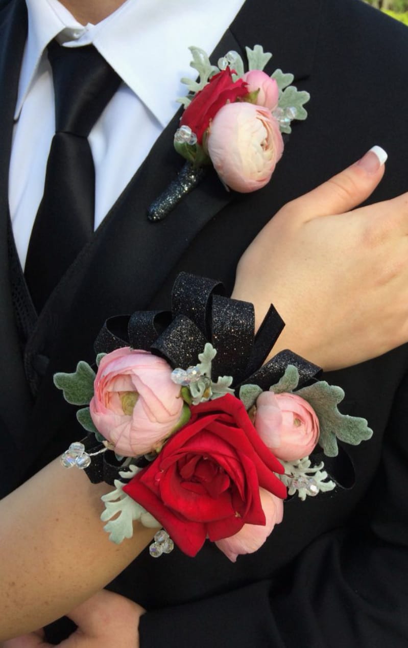 Boutonniere and wrist corsage with red and pink flowers on black ribbon