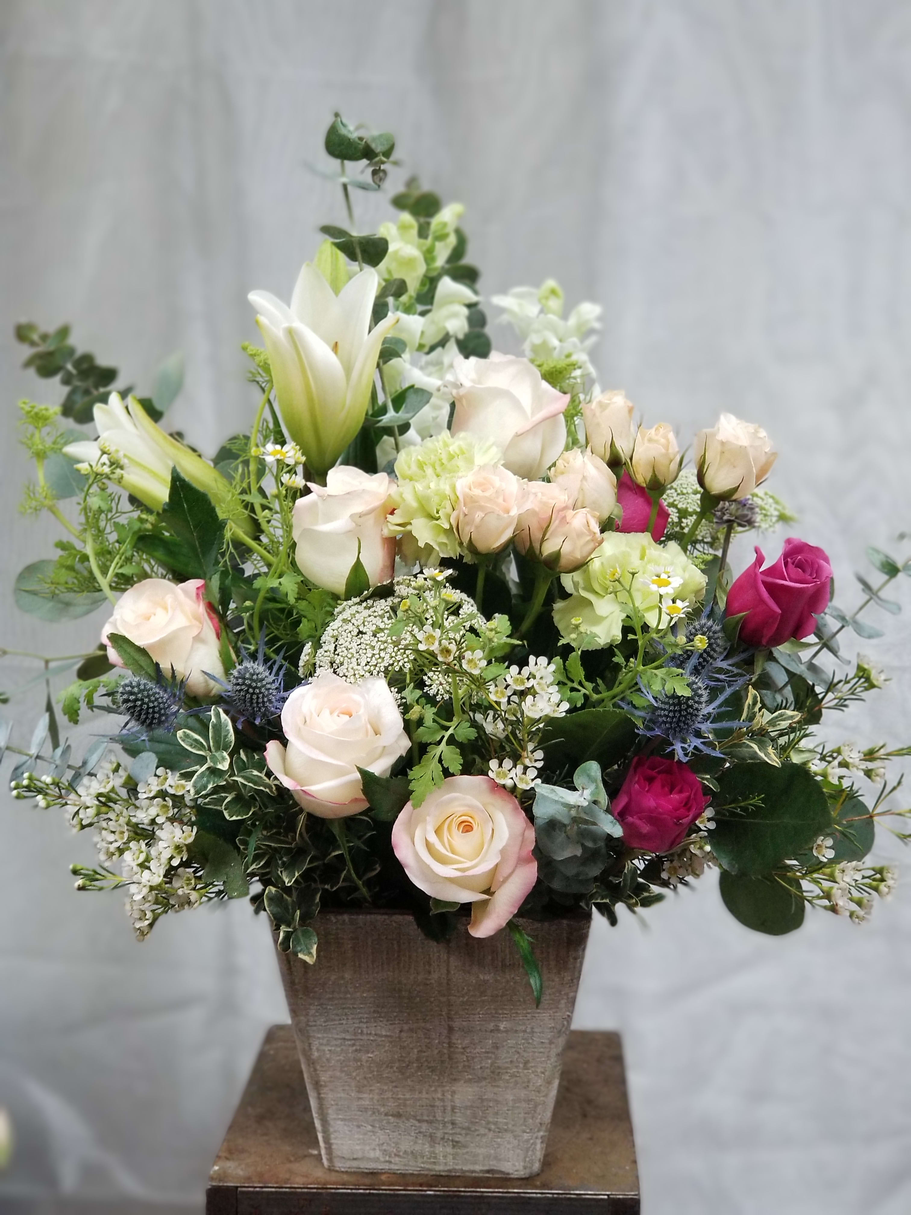 Mixed rose and lily arrangement in a square vase