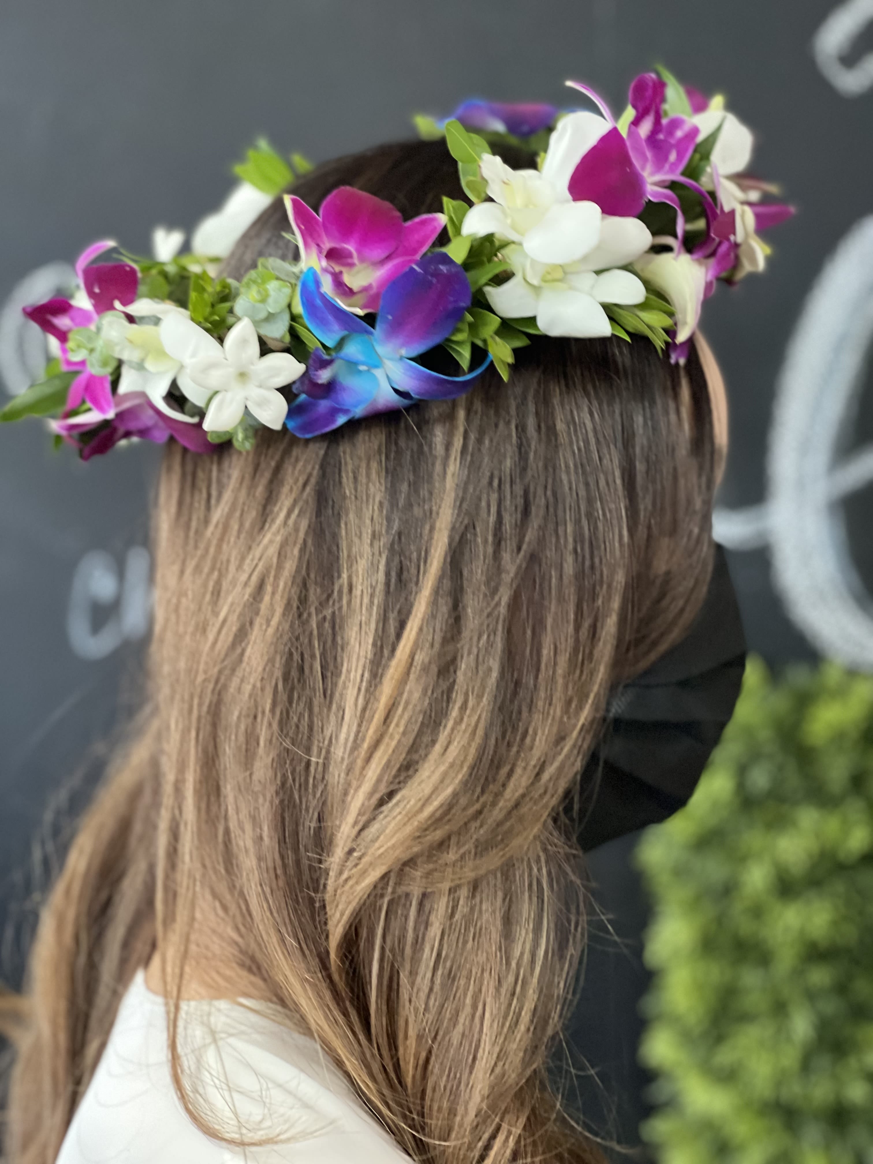 Flower crown with white and magenta orchids on a woman's head