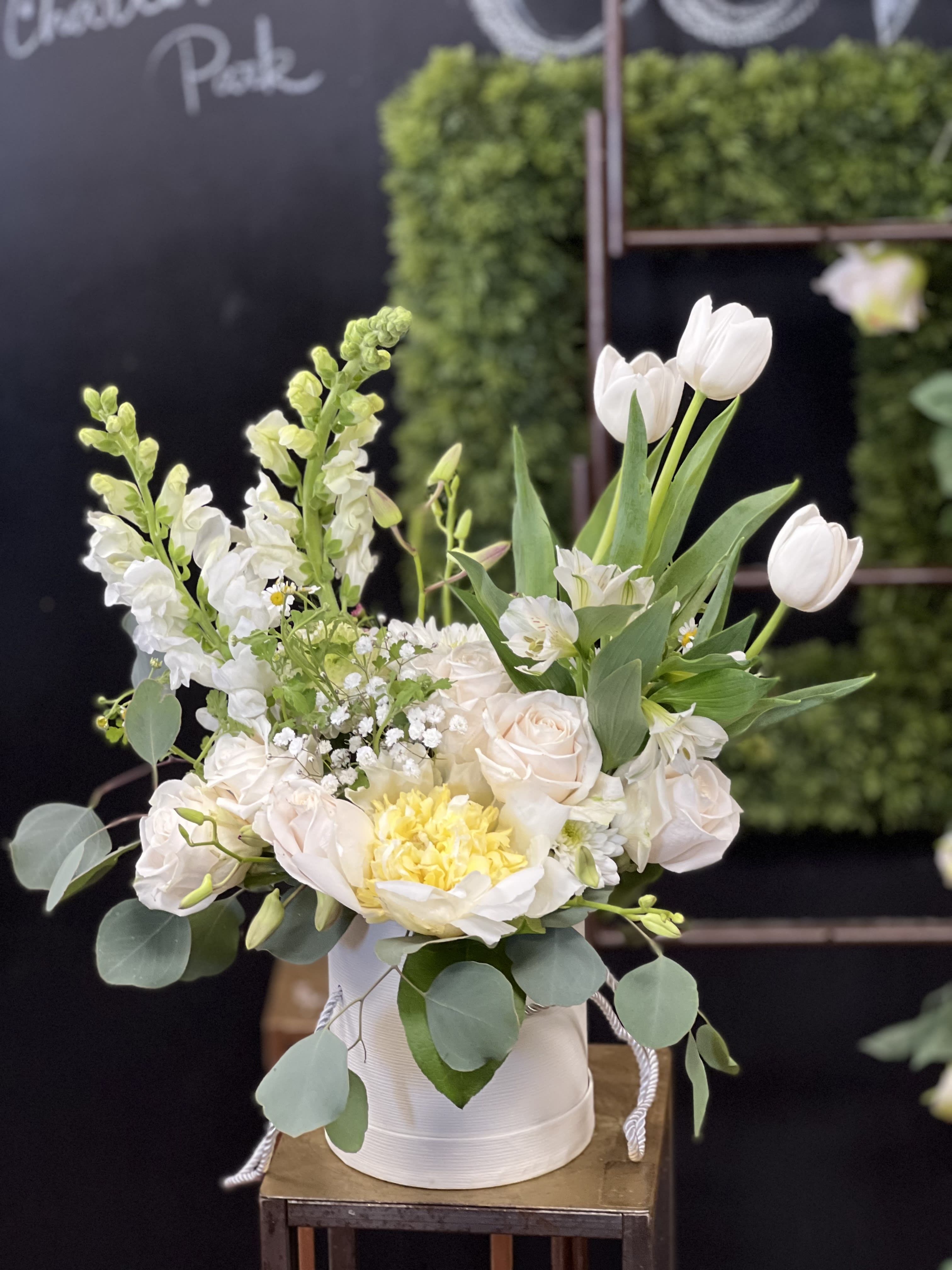 White and pale blush floral arrangement in a round white box