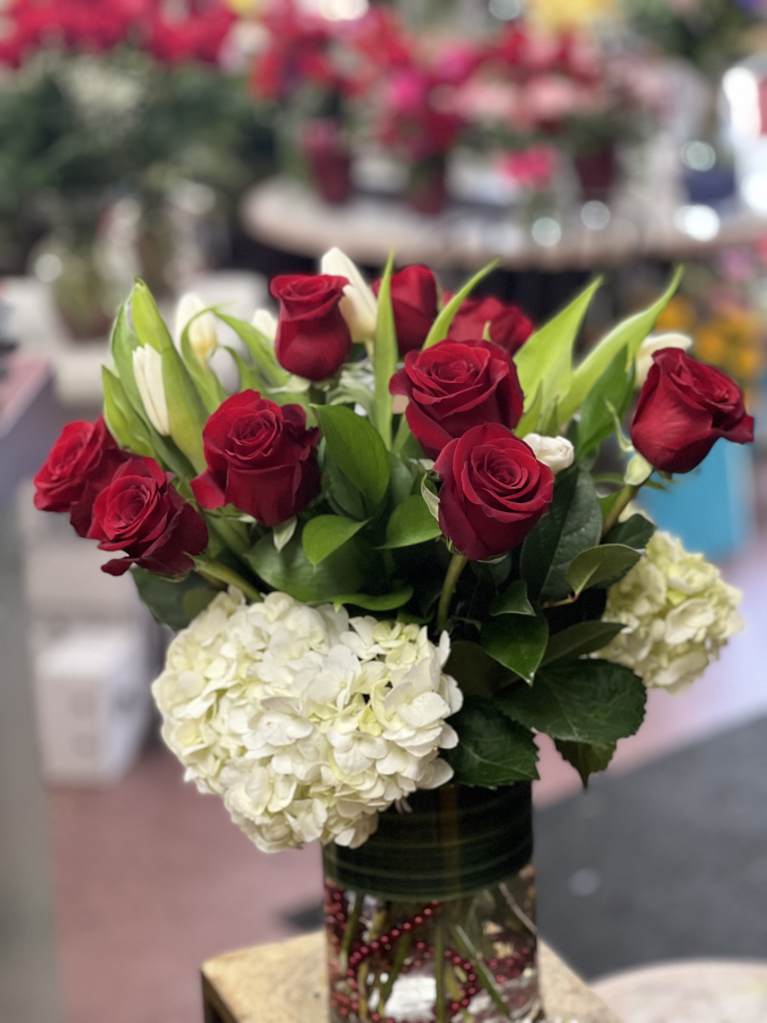 Red roses and white hydrangeas in a glass vase
