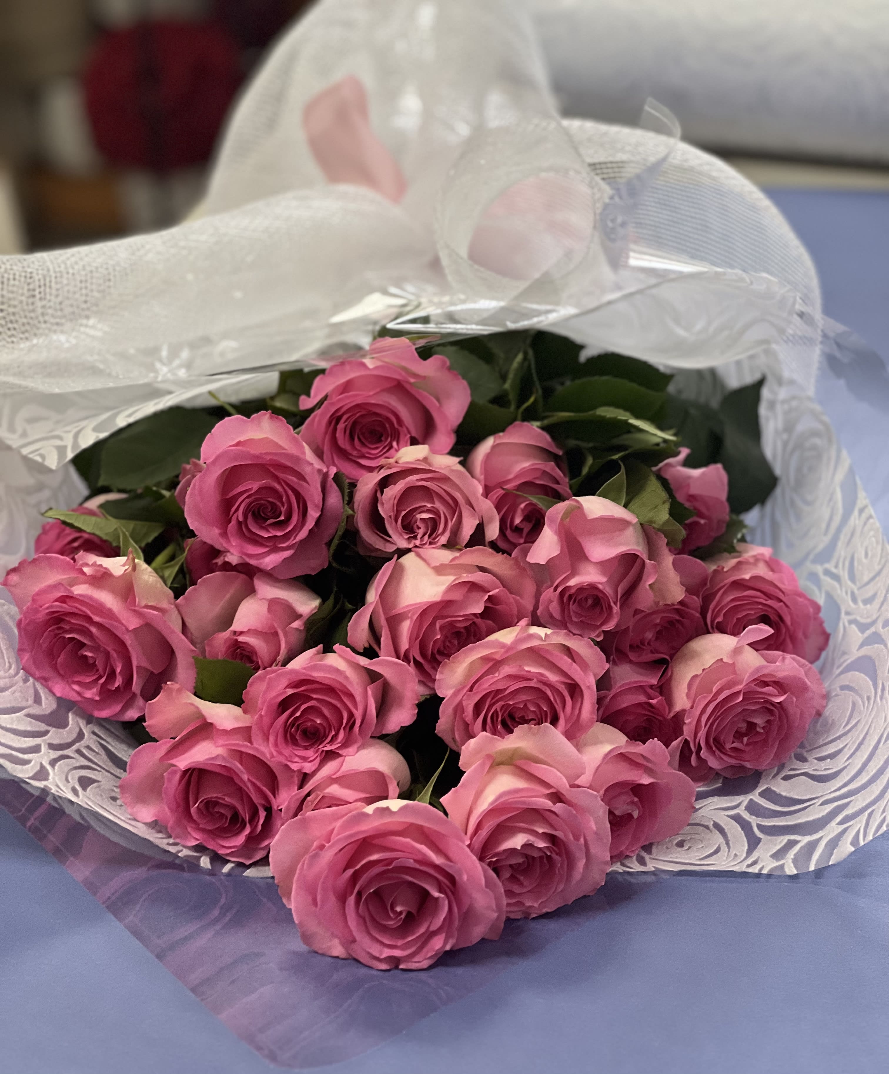 Bouquet of pink roses wrapped in white mesh paper