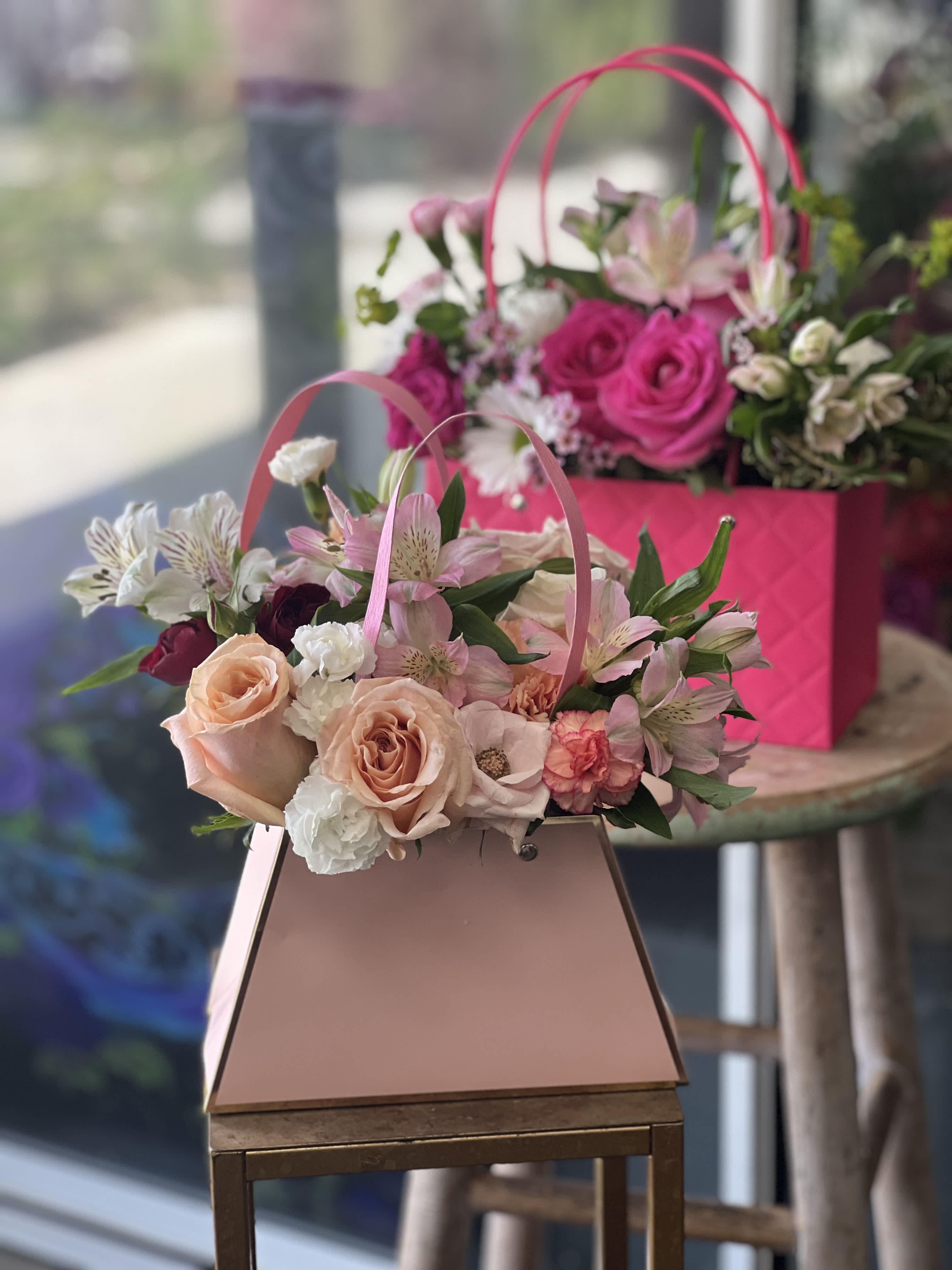 Pink and peach flower baskets with roses and alstroemeria