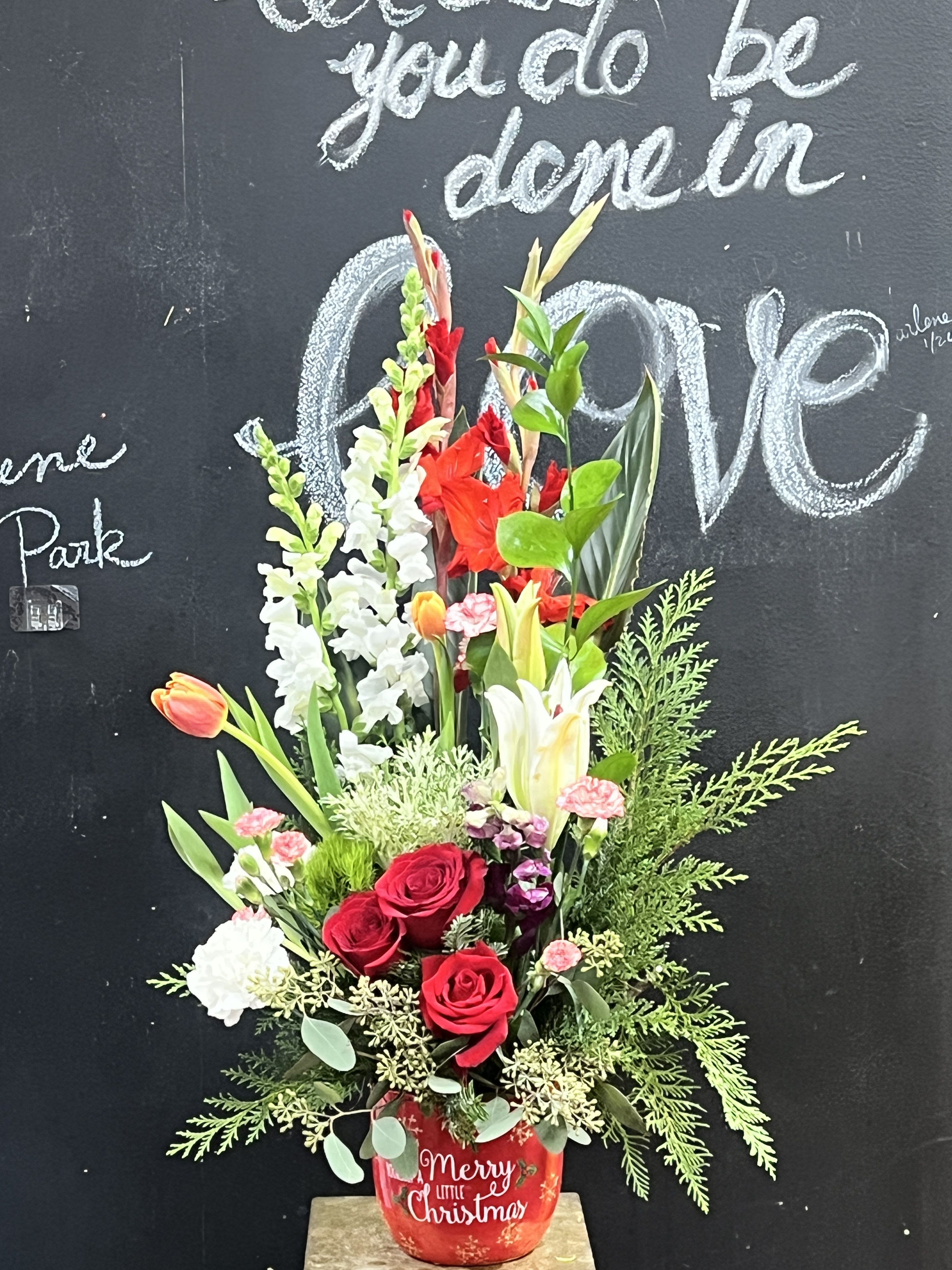 Red roses and mixed flowers in a red Christmas pot