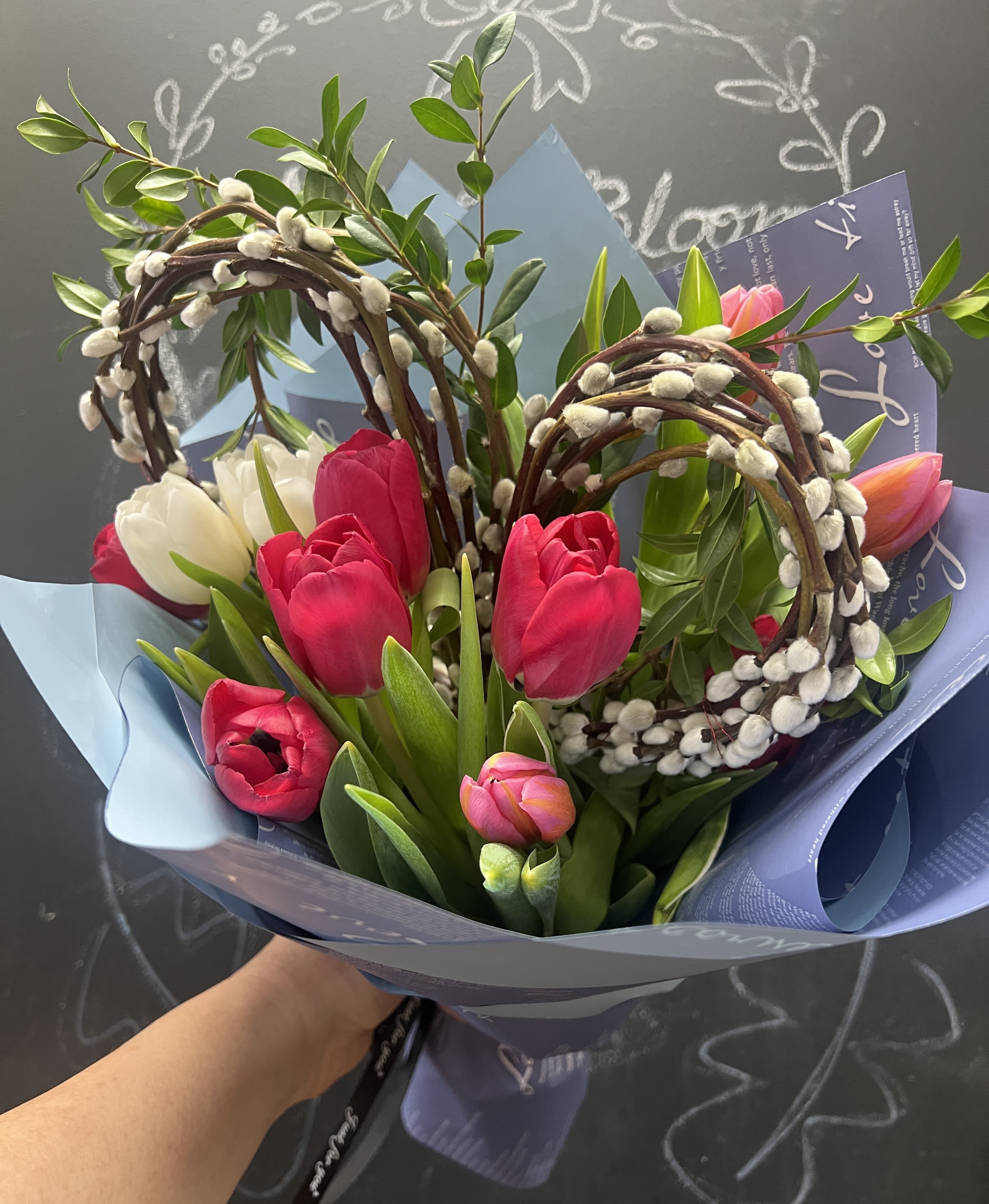 Bouquet of pink and white tulips wrapped in blue paper