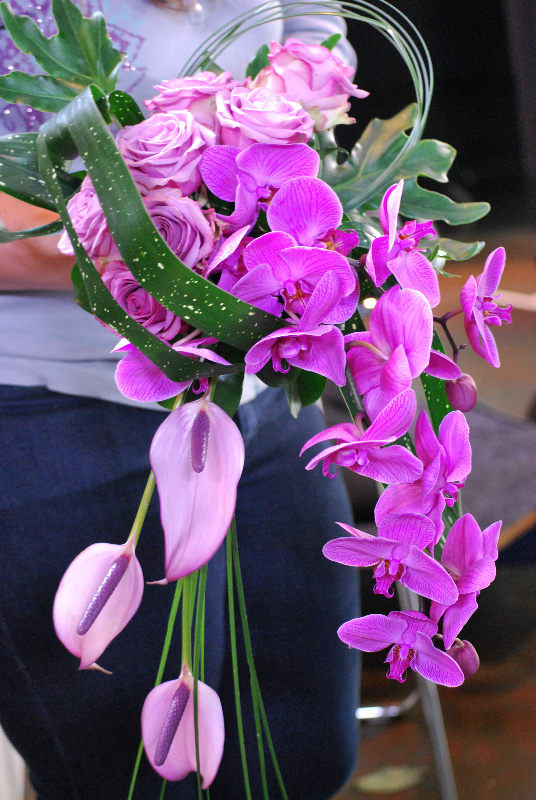 Pink roses and purple orchids in a cascading bouquet
