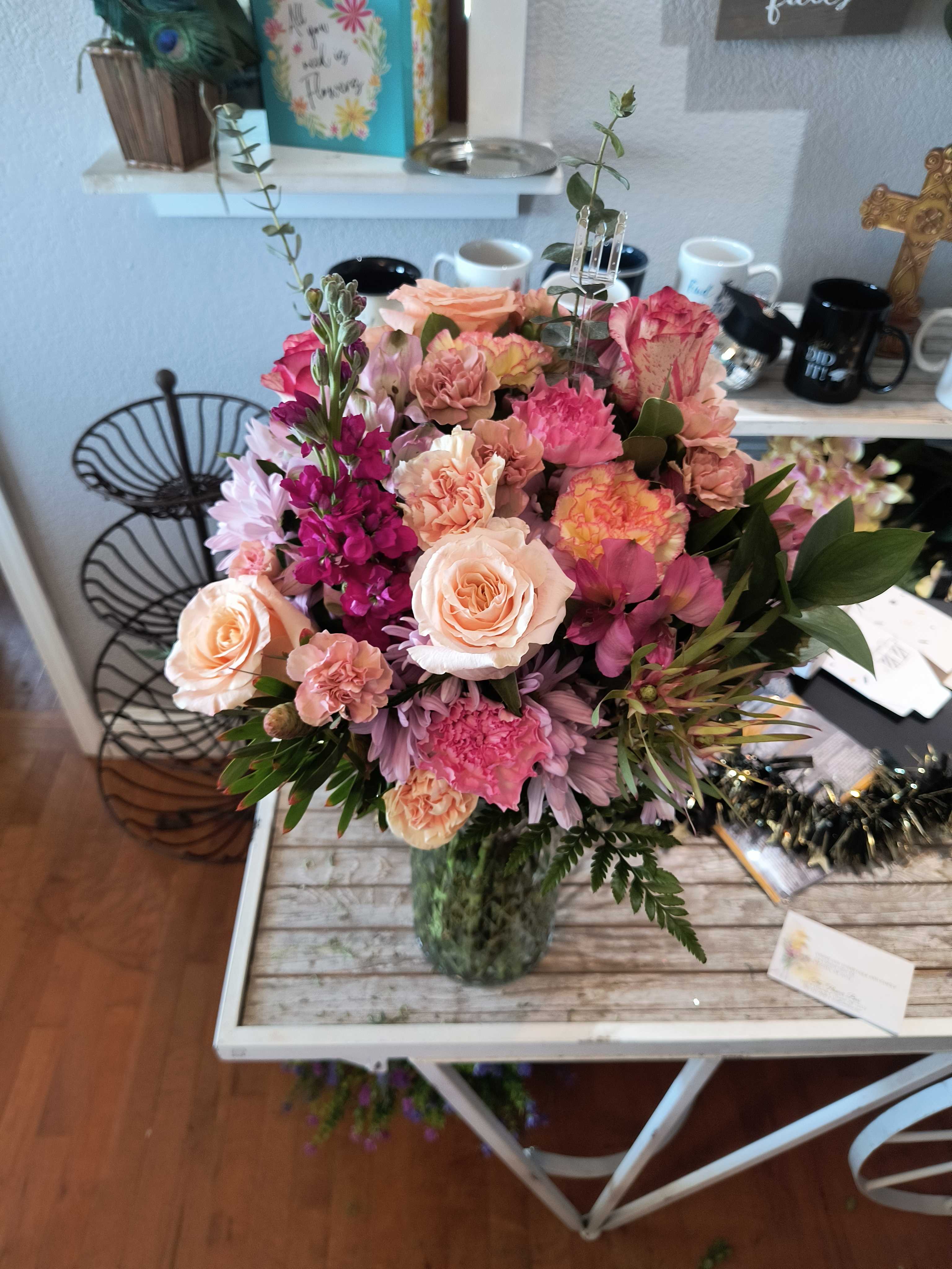 Mixed pink and peach flower bouquet in a glass vase