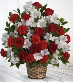 Red roses and white flowers arranged in a woven basket
