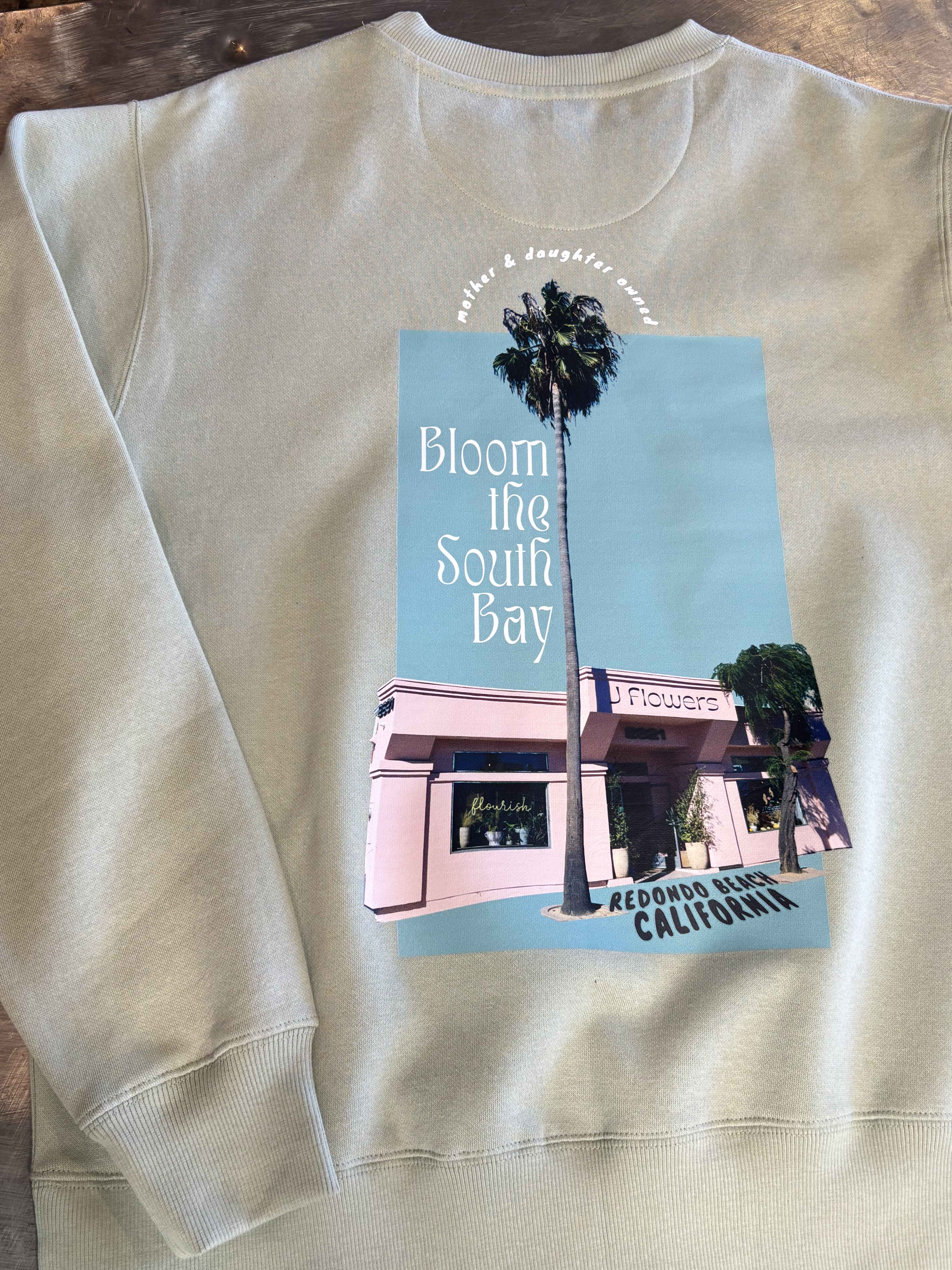 Beige sweatshirt with a printed flower shop graphic and palm trees