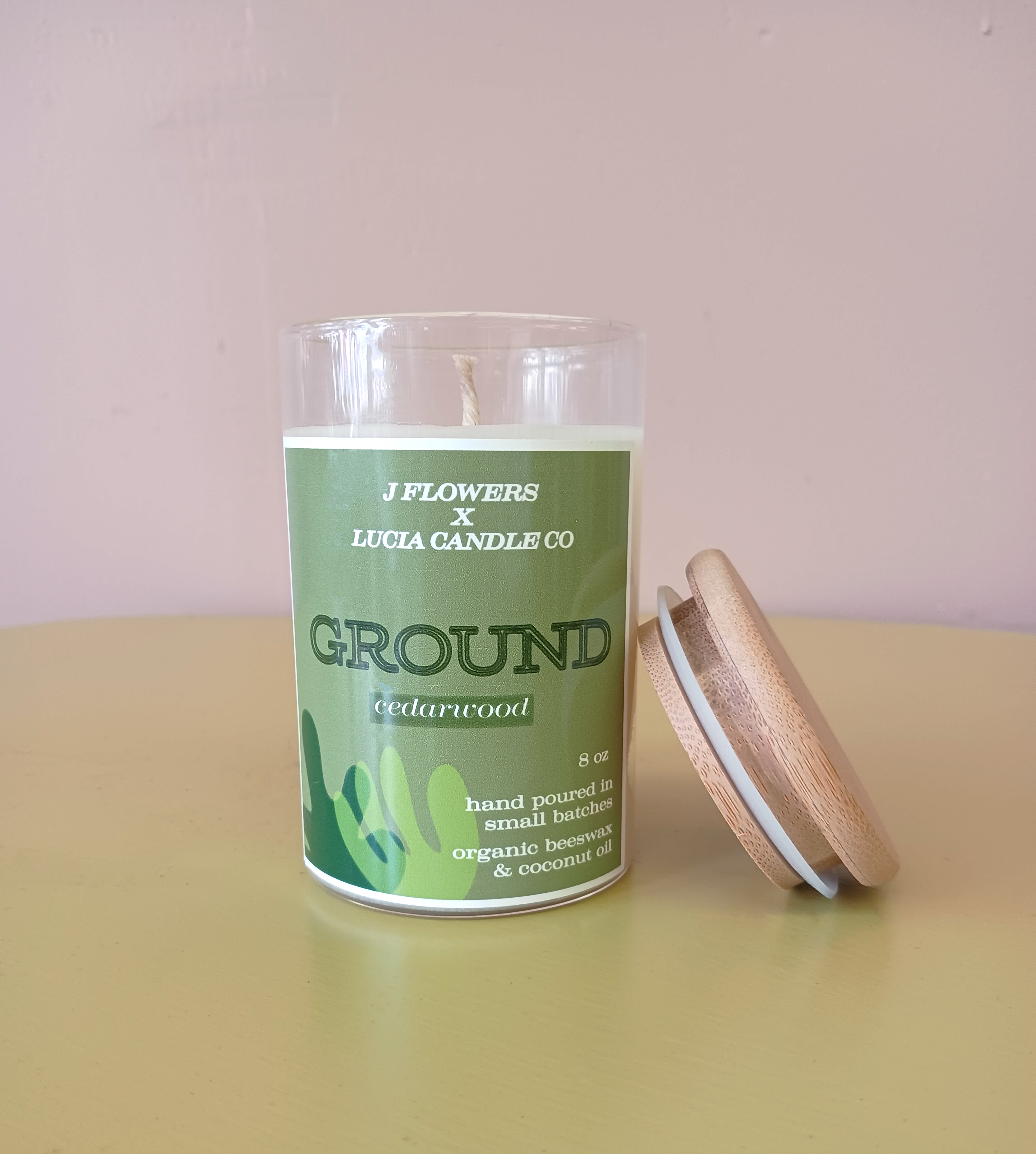 Green cedarwood candle in a glass jar with a wooden lid