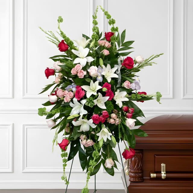 Standing floral spray with white lilies, pink roses, and red roses