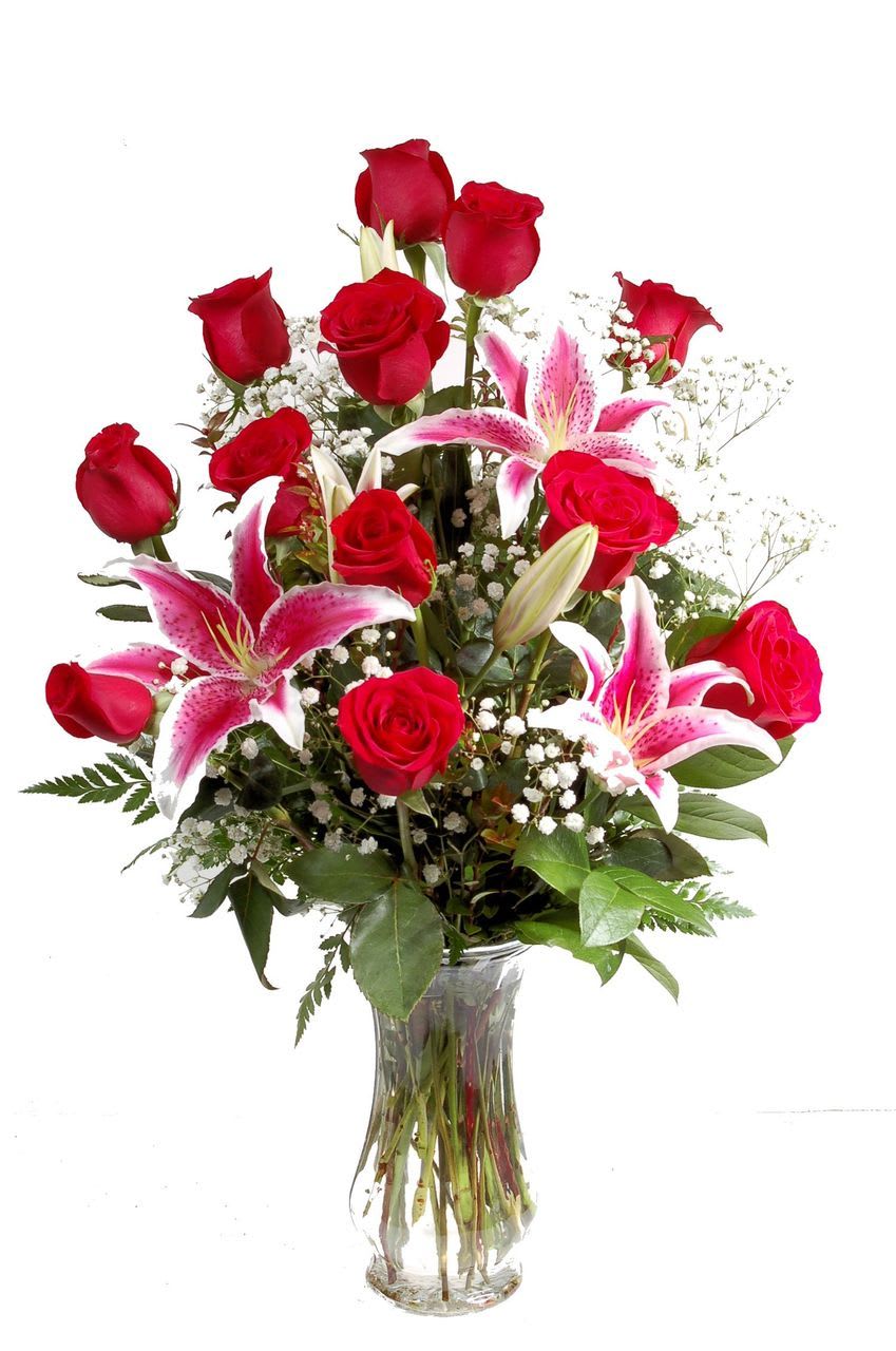 Red roses and pink lilies in a clear glass vase