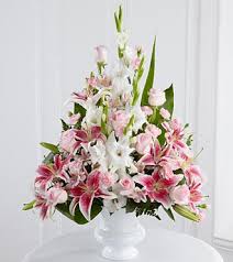 Pink and white lily arrangement in a clear vase