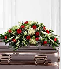 Red and white floral casket spray on a silver casket