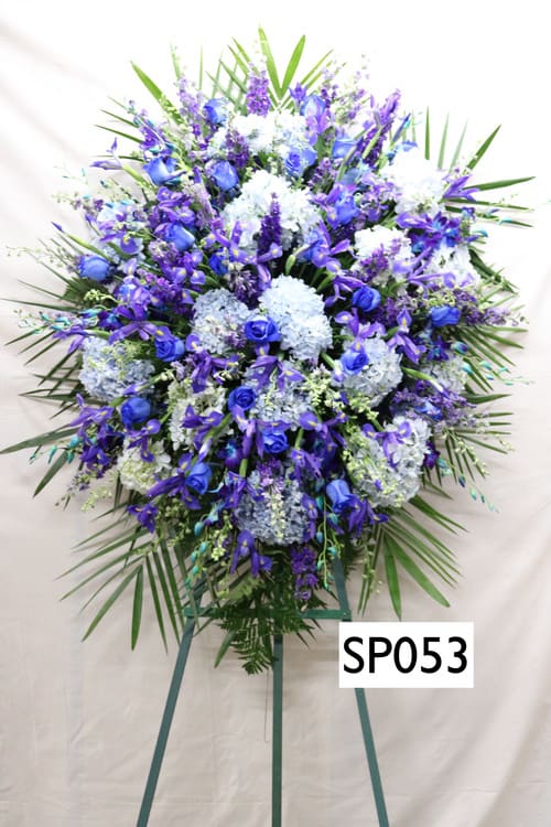 Large blue and white funeral spray on a standing easel