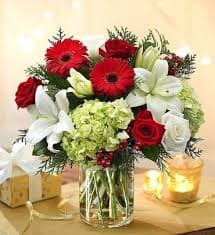 Red roses, white lilies, and red gerberas in a glass vase