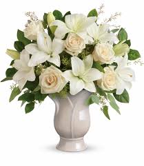 White lilies and cream roses in a pale vase