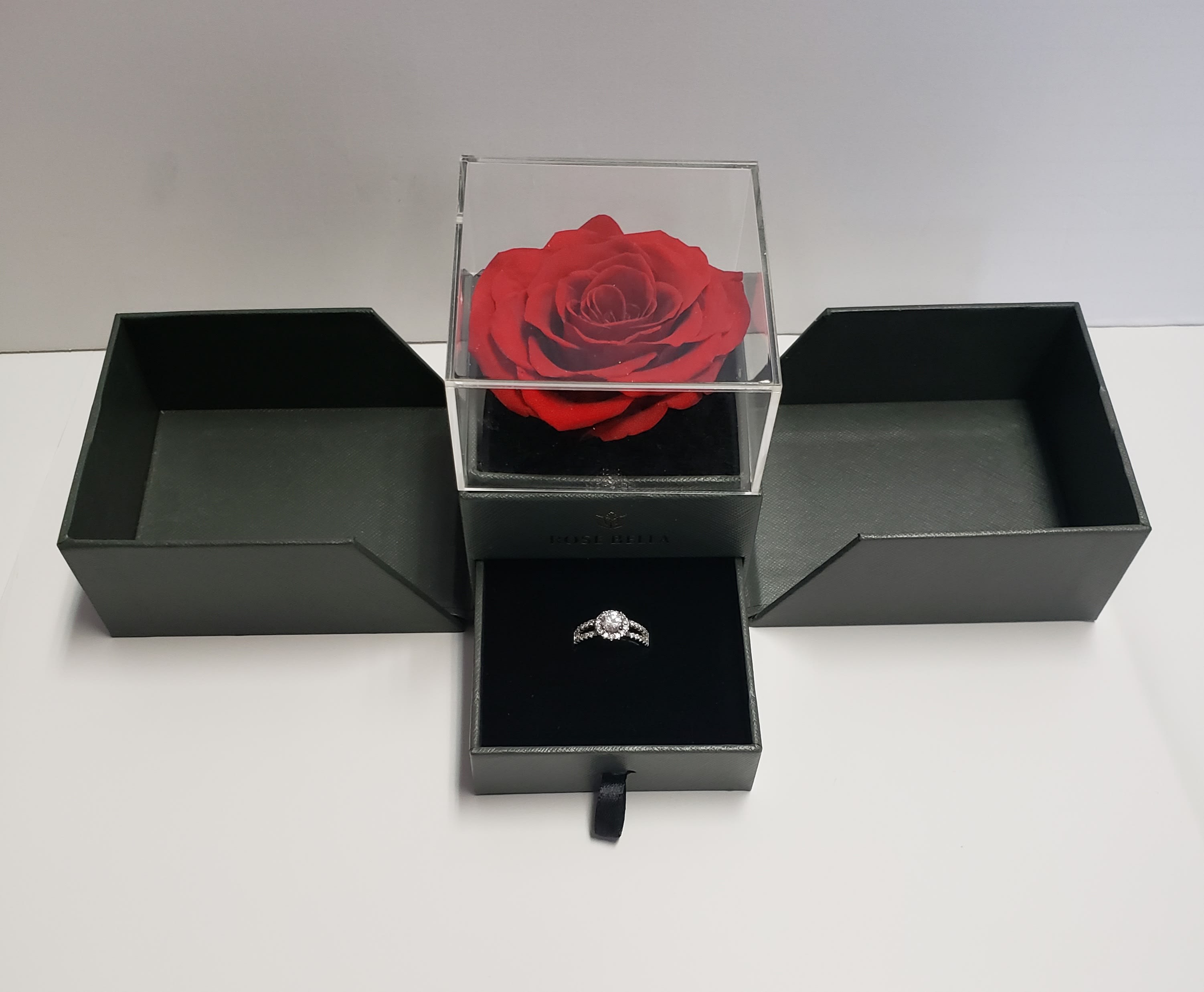 Red rose in a clear box with a ring in a black jewelry box