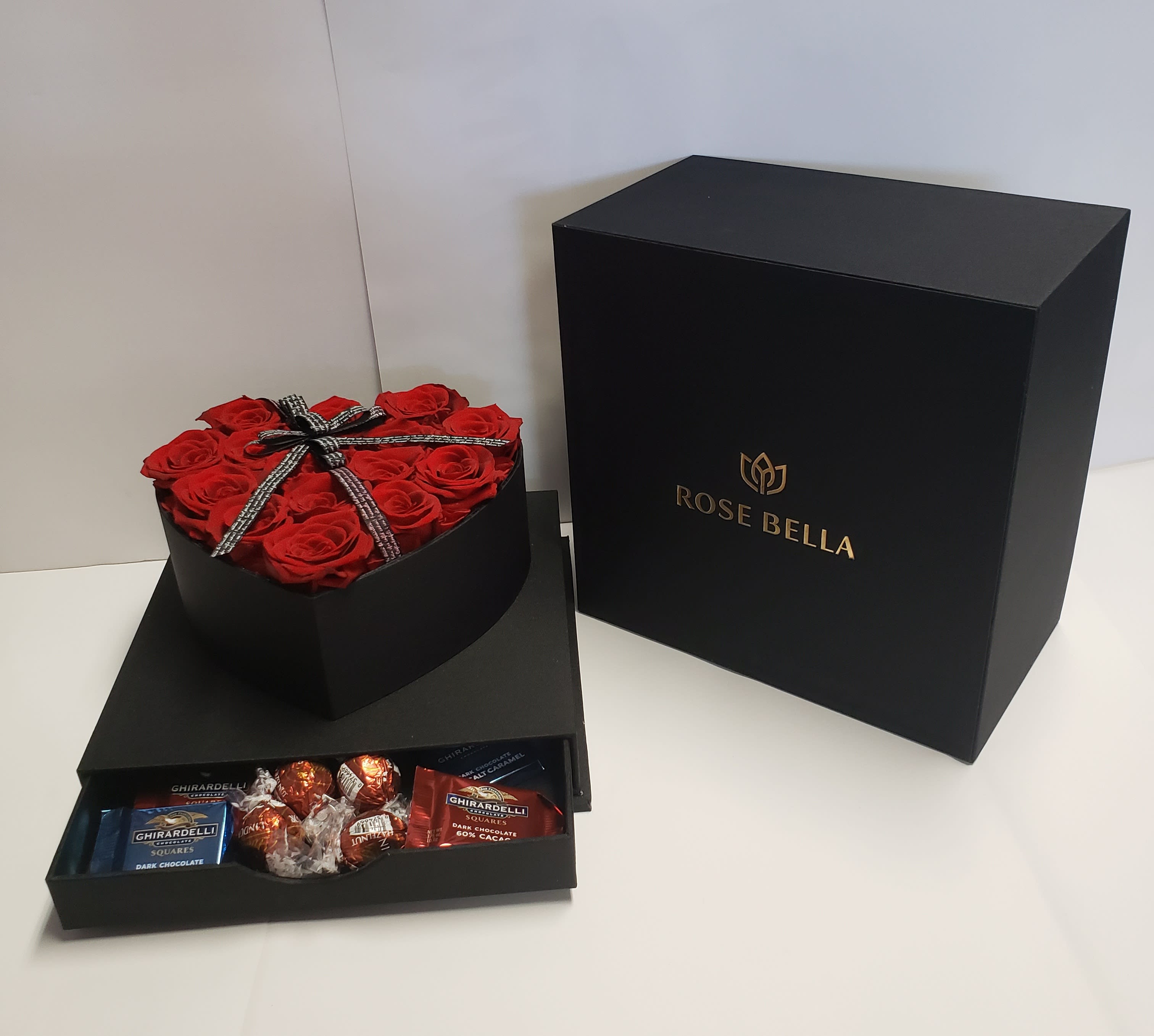Heart-shaped box of red roses with chocolates in a black gift box