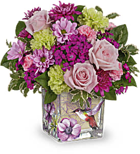 Pink and purple bouquet in a square glass vase with a bird design