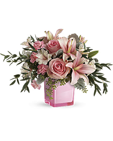Pink roses and lilies arranged in a pink glass vase
