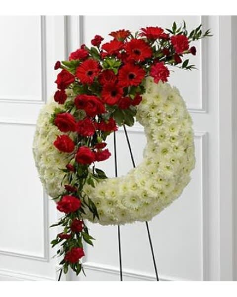 Red and white floral wreath on a stand