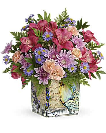 Mixed pink and purple bouquet in a butterfly-patterned square vase
