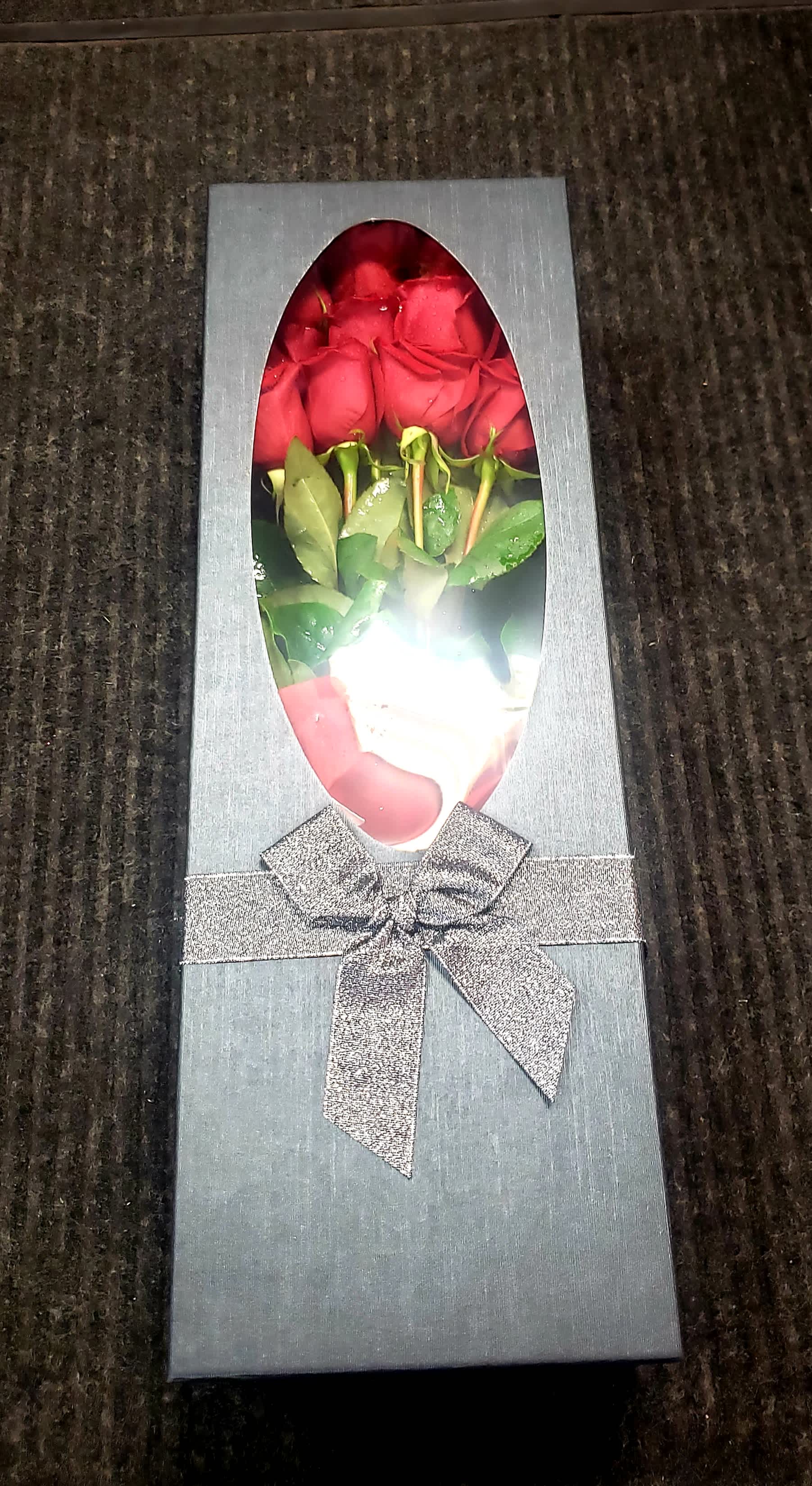 Box of red roses with a silver ribbon bow