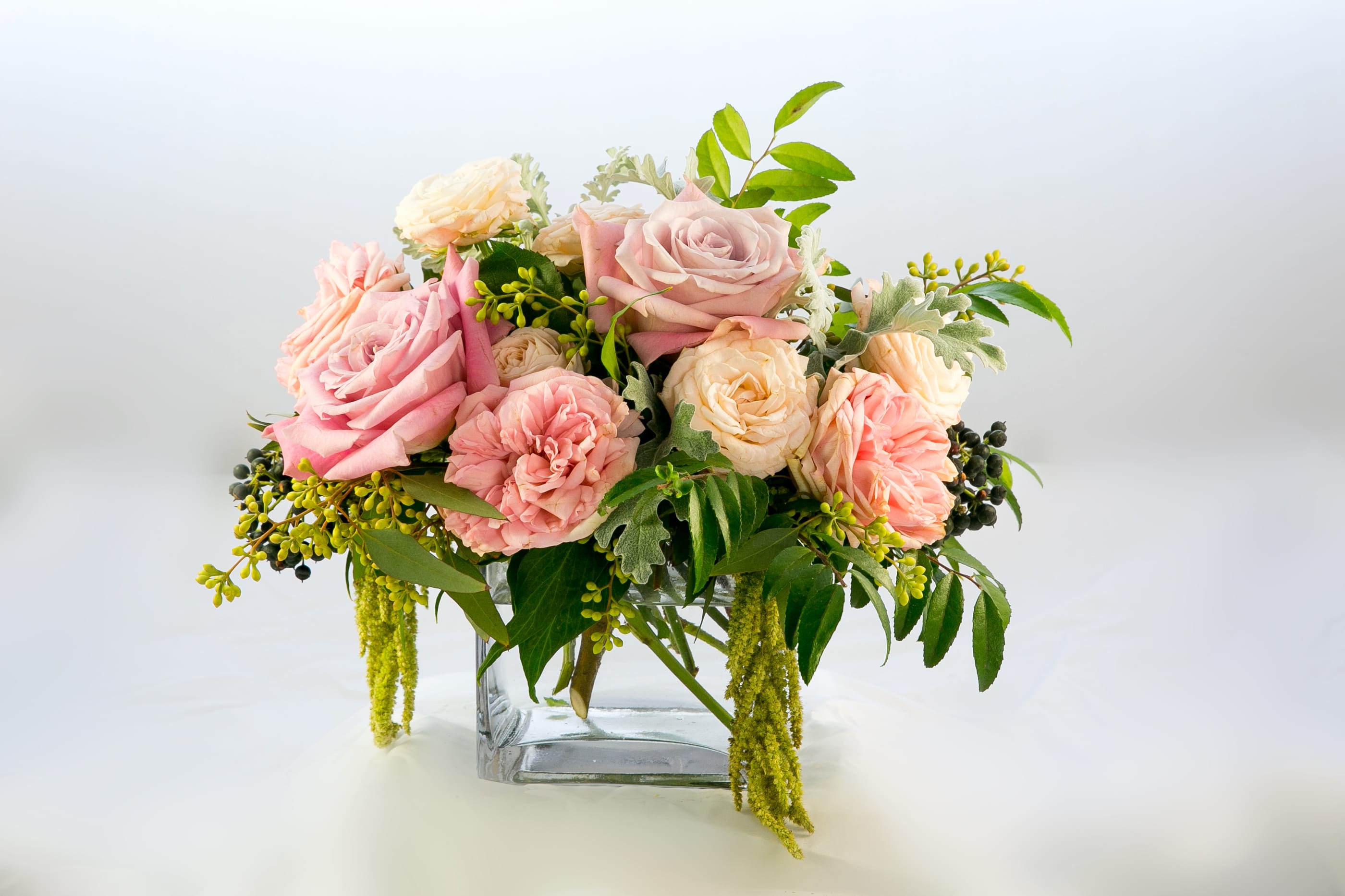 Pink and cream roses arranged in a clear glass vase
