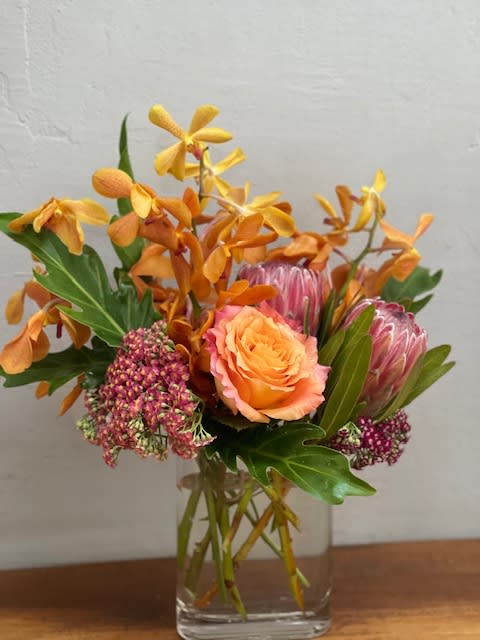 Orange and pink floral arrangement in a clear glass vase
