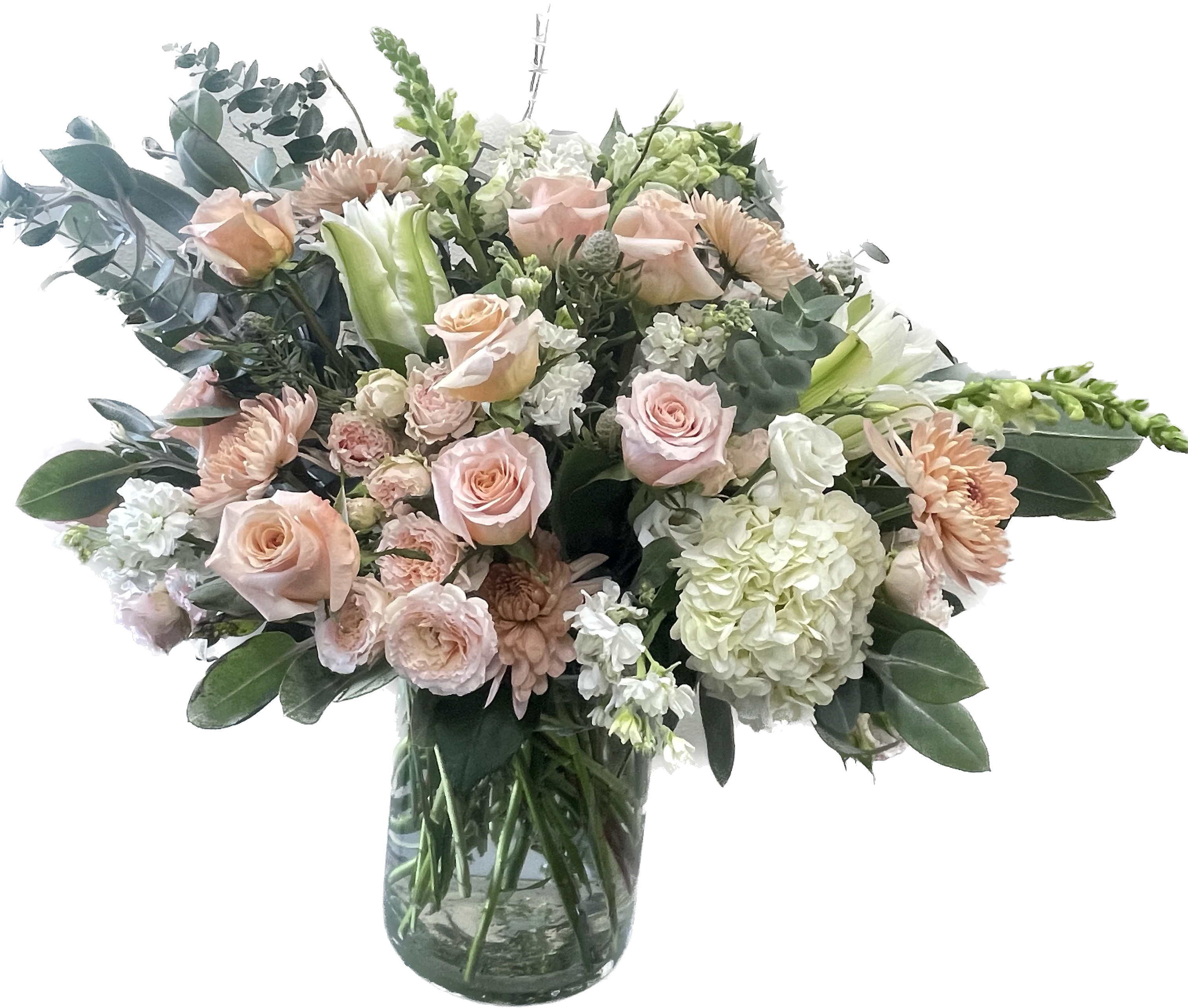 Blush roses and pale flowers in a clear glass vase