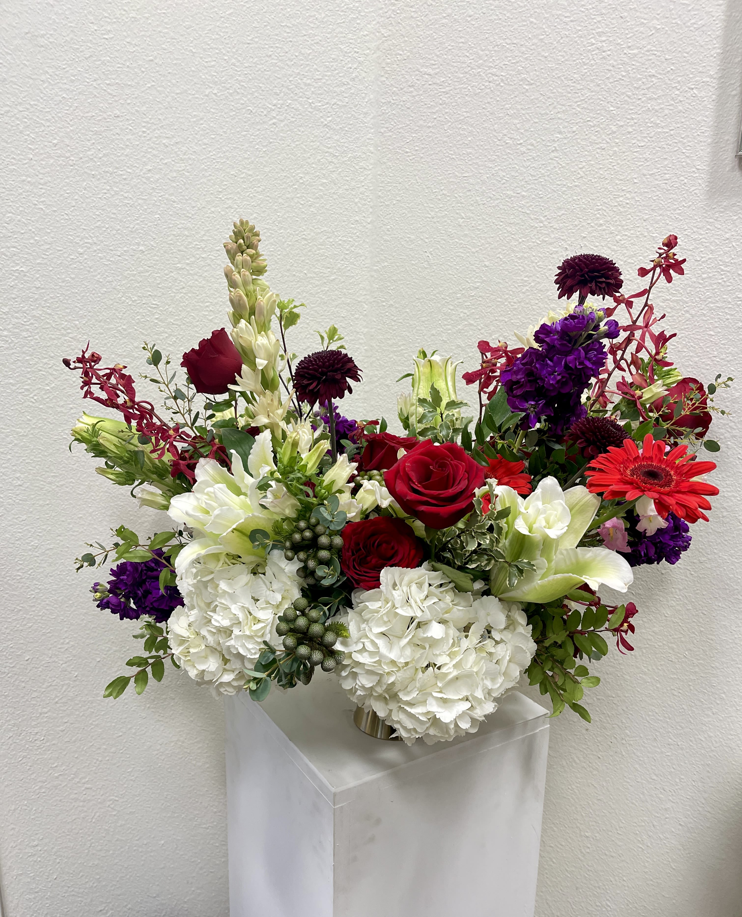 Mixed bouquet of red, white, and purple flowers in a vase