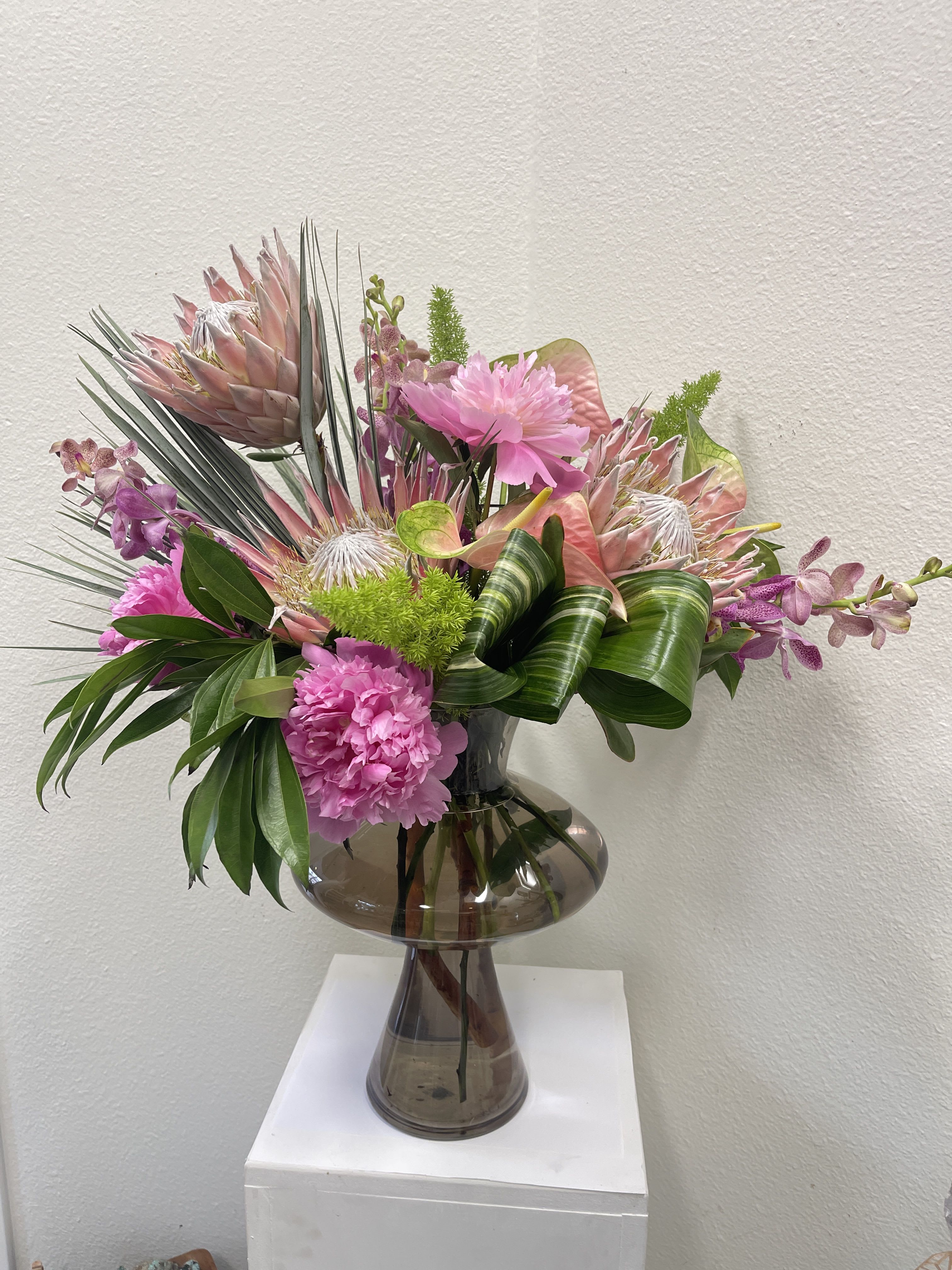 Pink tropical bouquet in a smoked glass vase
