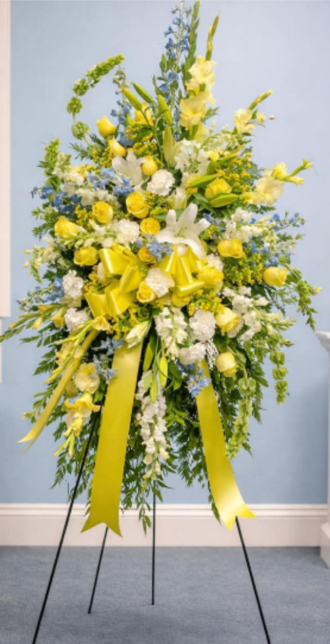 Eternal Sunshine Spray Stand - A yellow and white standing spray for a grand, traditional sympathy display crafted to bring a sense of peace, warmth, and light to a memorial service *Premium Size Shown*