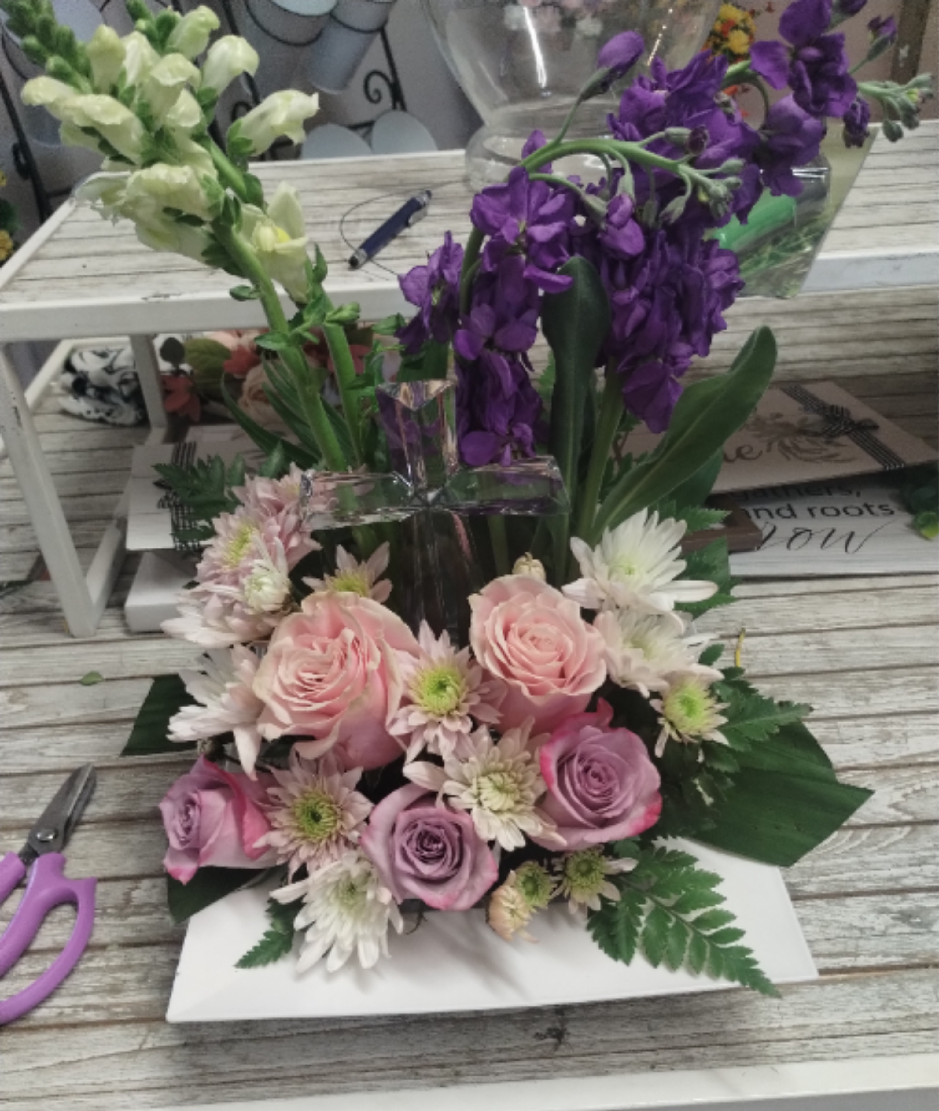 Grace &amp; Glory Arrangement - This Grace &amp; Glory arrangement, with a crystal cross, is a beautiful, comforting tabletop sympathy tribute that elegantly blends a lasting token of faith with soft, premium blooms *Standard Size Shown*