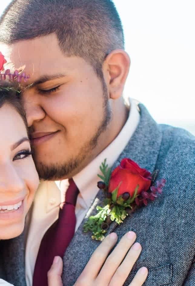 Couple embracing, with a red rose boutonniere on the man's jacket