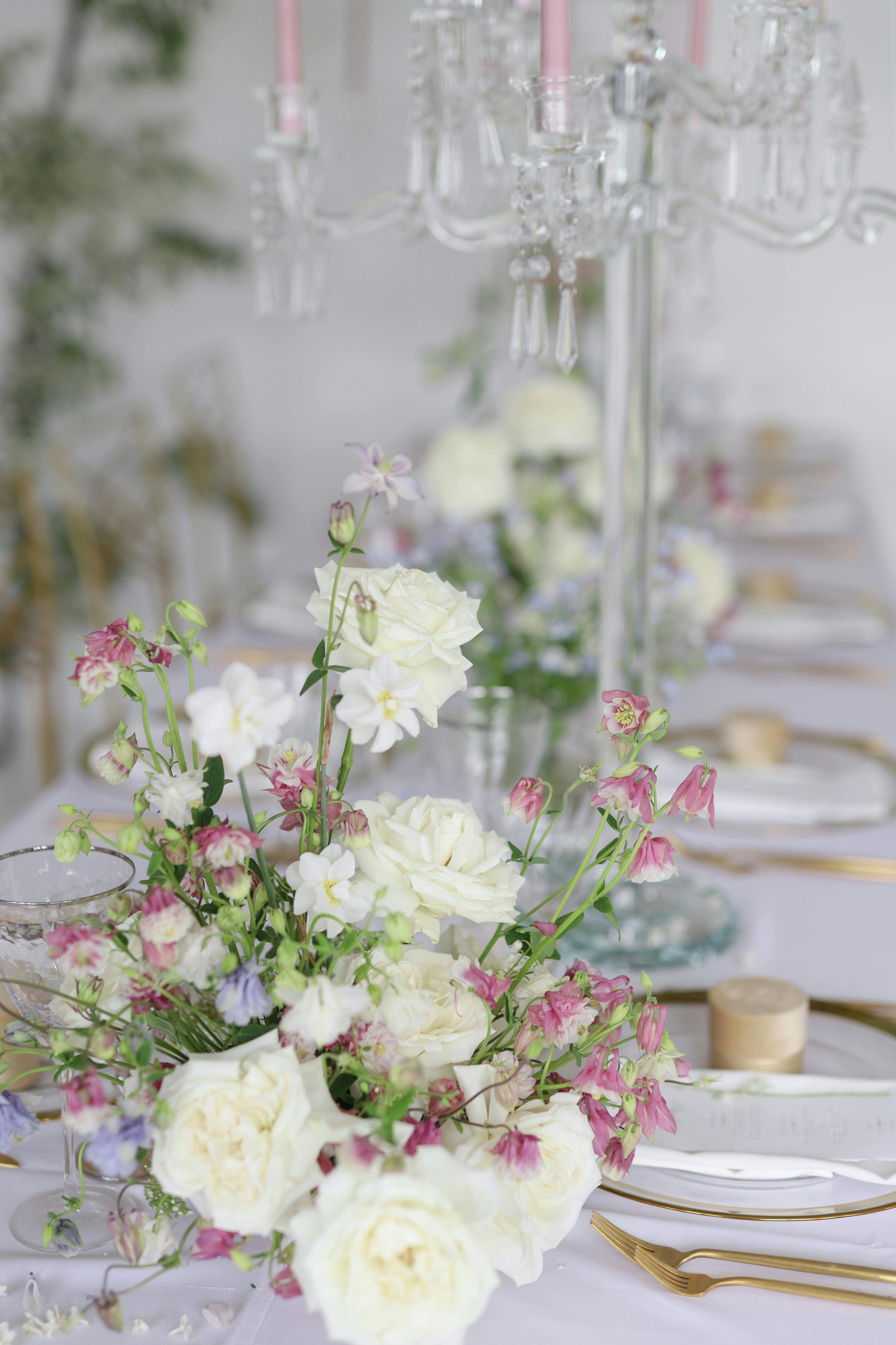 White and pink floral centerpiece on a set table