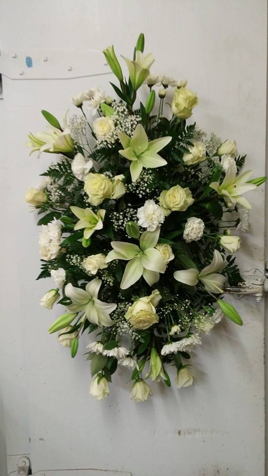 White lilies and roses arranged in a large standing spray