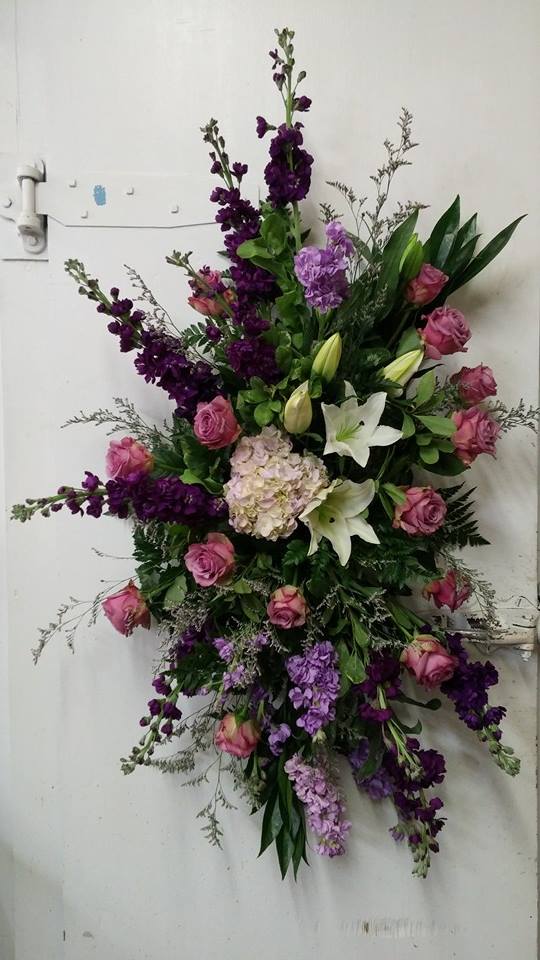 Tall floral spray with pink roses, white lilies, and purple blooms