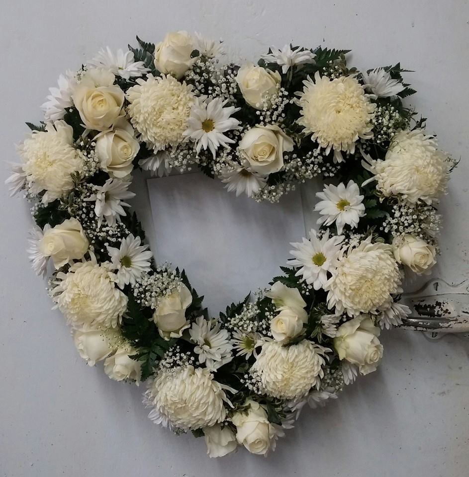 Heart-shaped white floral wreath with roses and daisies
