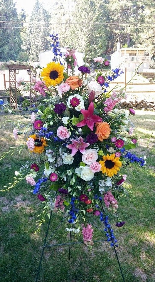 Tall standing floral spray with sunflowers, lilies, and mixed blooms