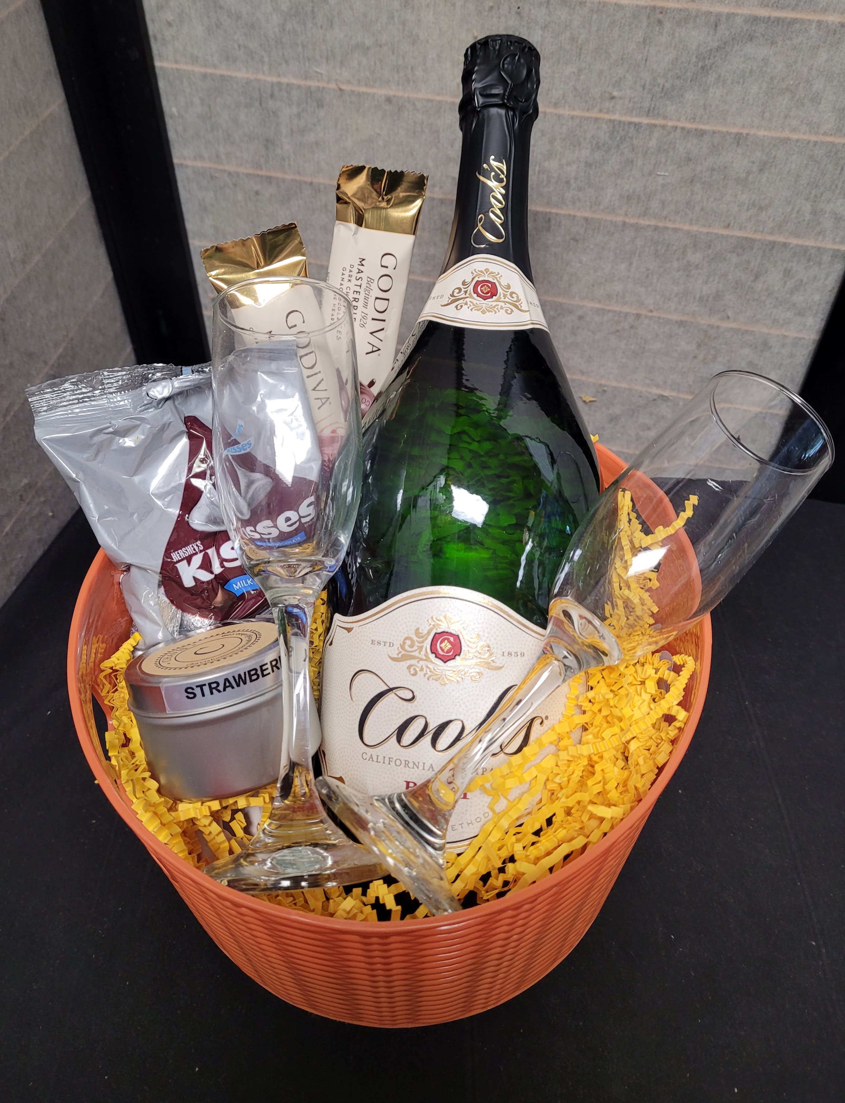 Gift basket with champagne, chocolates, and two flutes