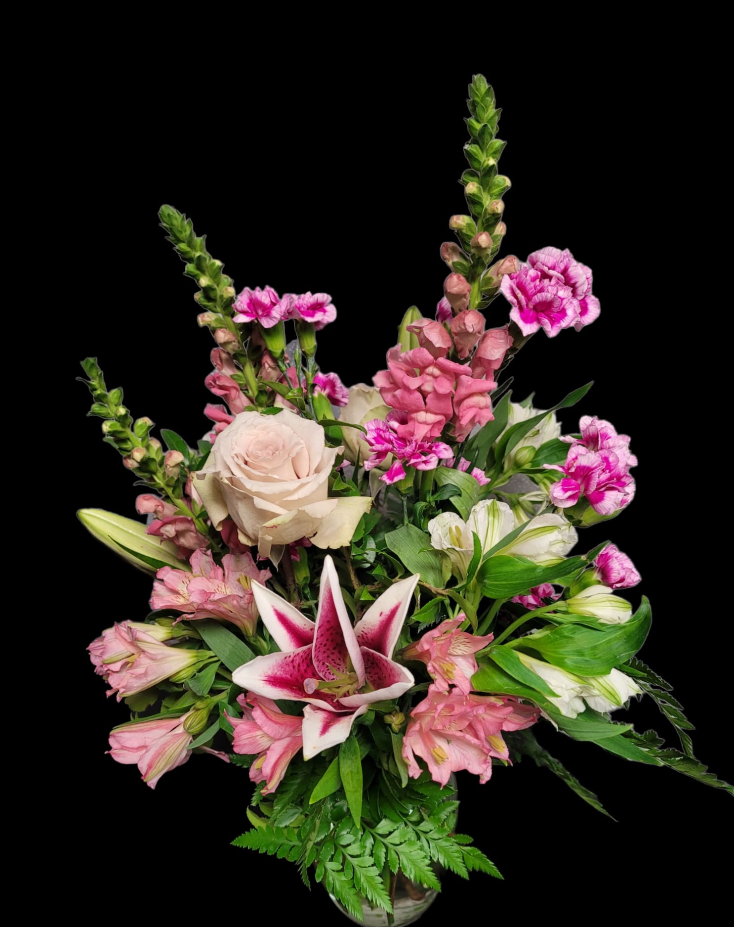 Pink and white mixed flower arrangement with a central lily in a vase
