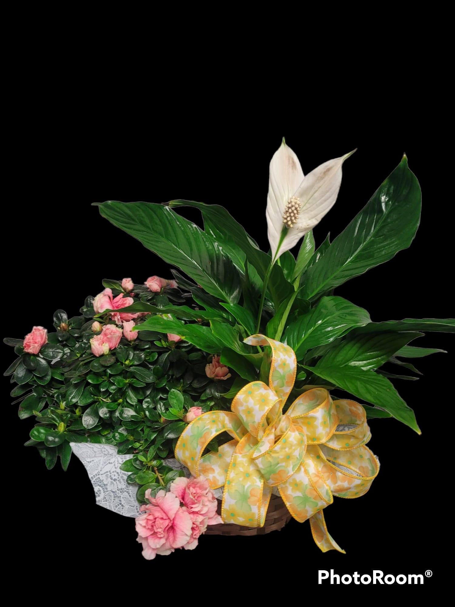 Basket arrangement with pink carnations, white peace lily, and a yellow ribbon