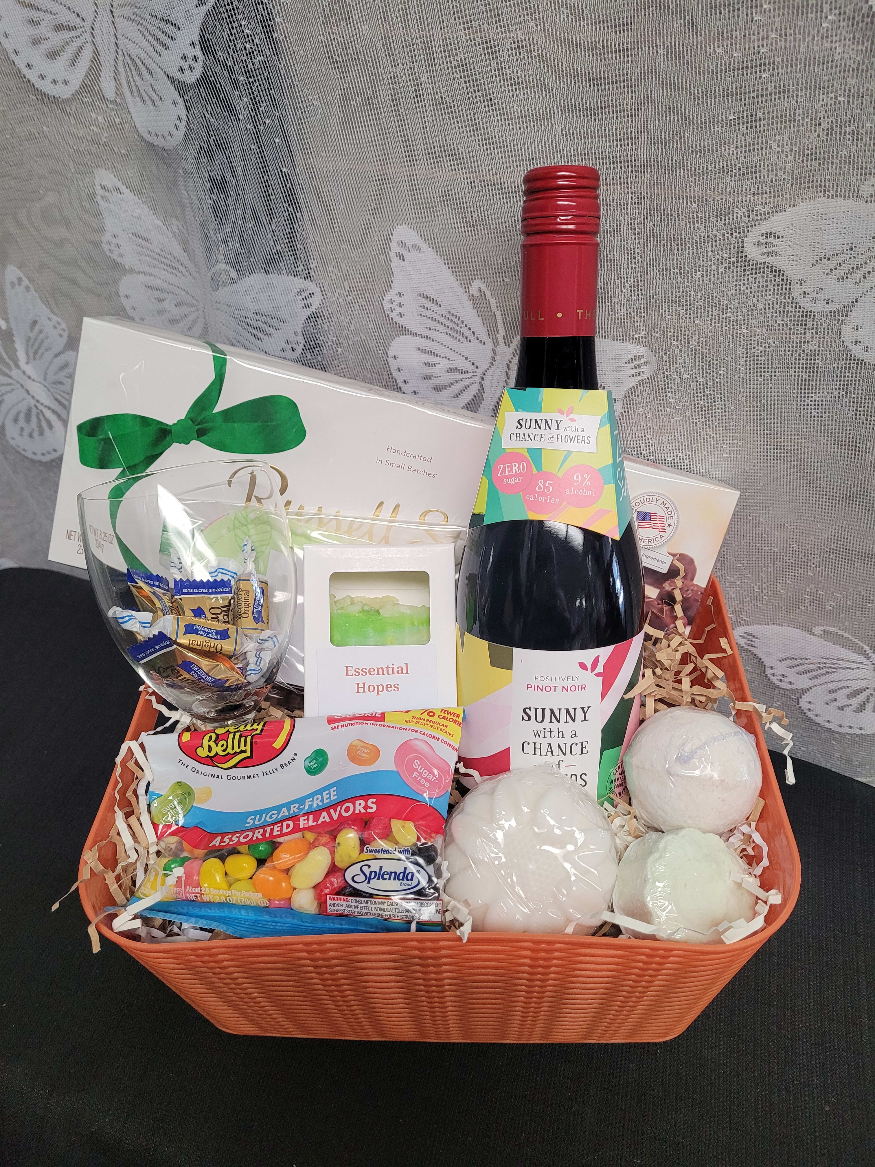 Gift basket with wine, candy, a glass, and bath items