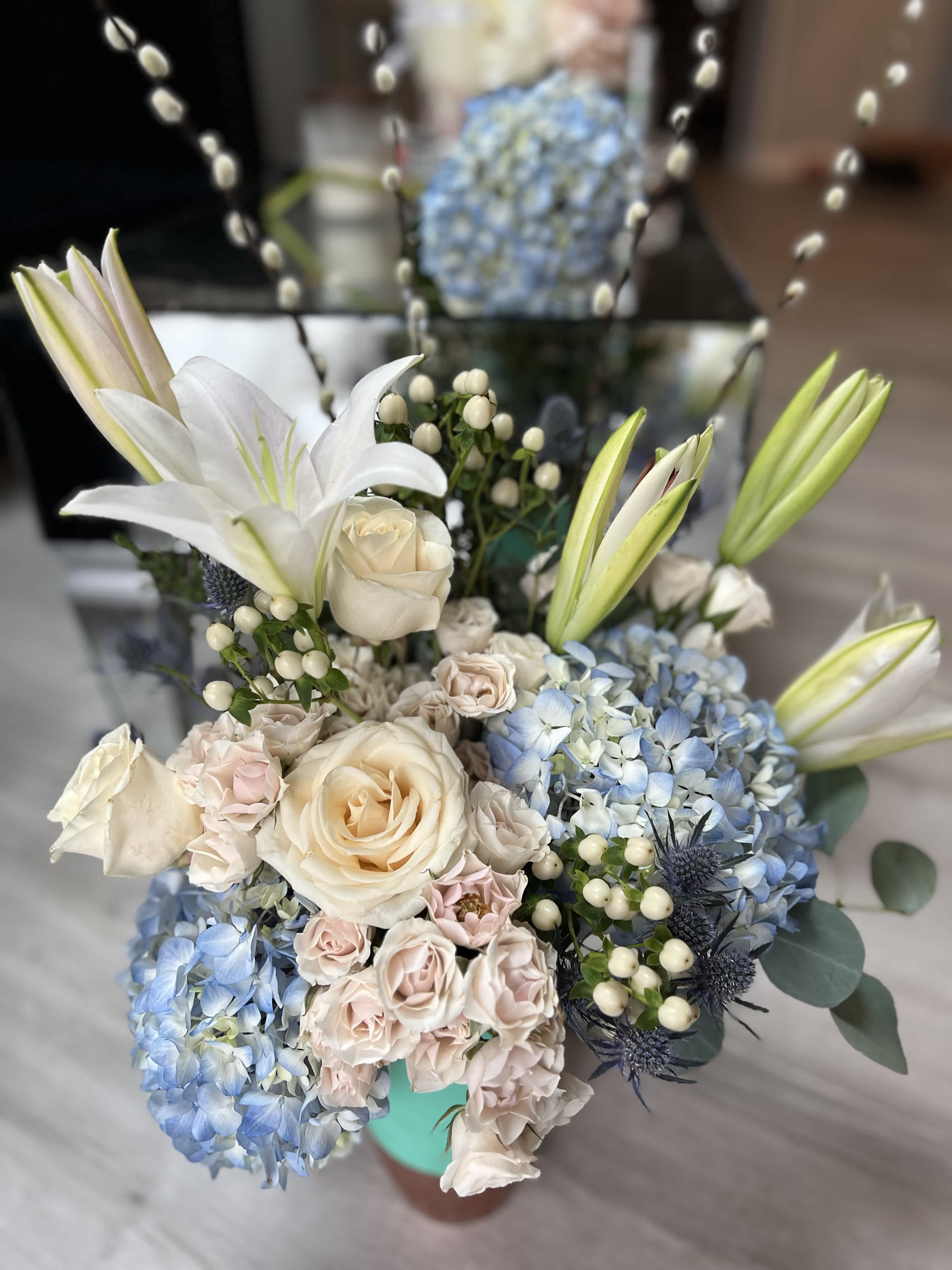 Bouquet of white lilies, cream roses, and blue hydrangeas