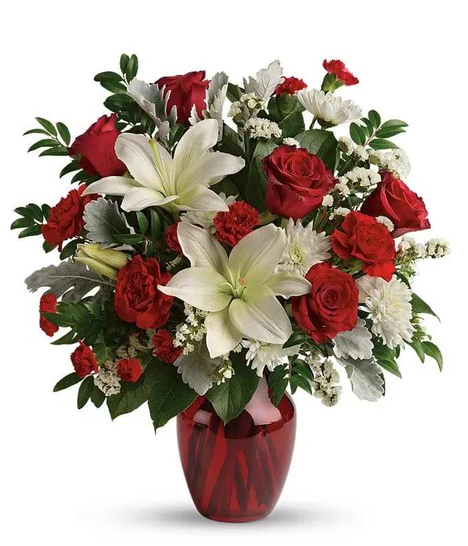 Red roses and white lilies in a red glass vase