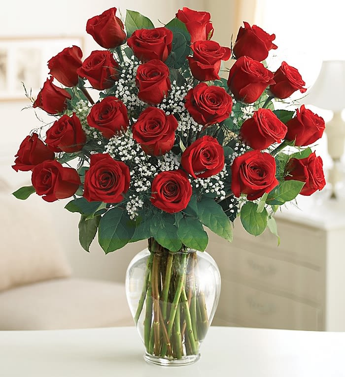 Bouquet of red roses with baby's breath in a clear glass vase