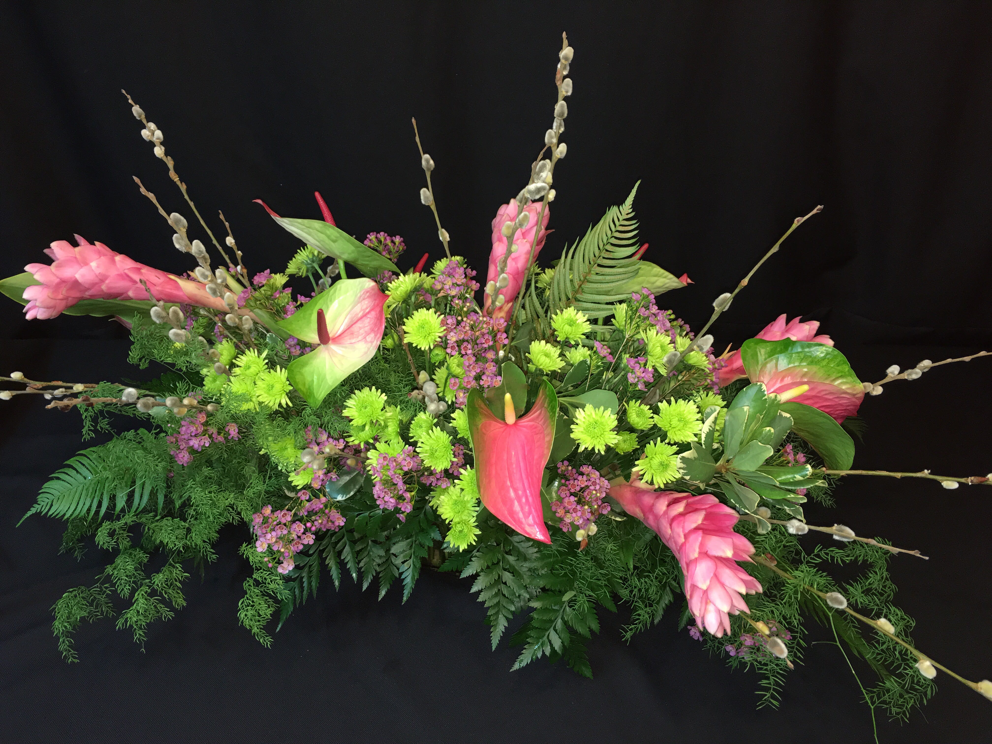 Tropical Paradise Centerpiece  - Luxurious exotic tropical flowers in a low dining table Centerpiece. Ginger, Anthurium and fern plus pussywillow branches make an interesting display. Selection will vary from week to week. We welcome your color preferences with at least 2 week advance order. 