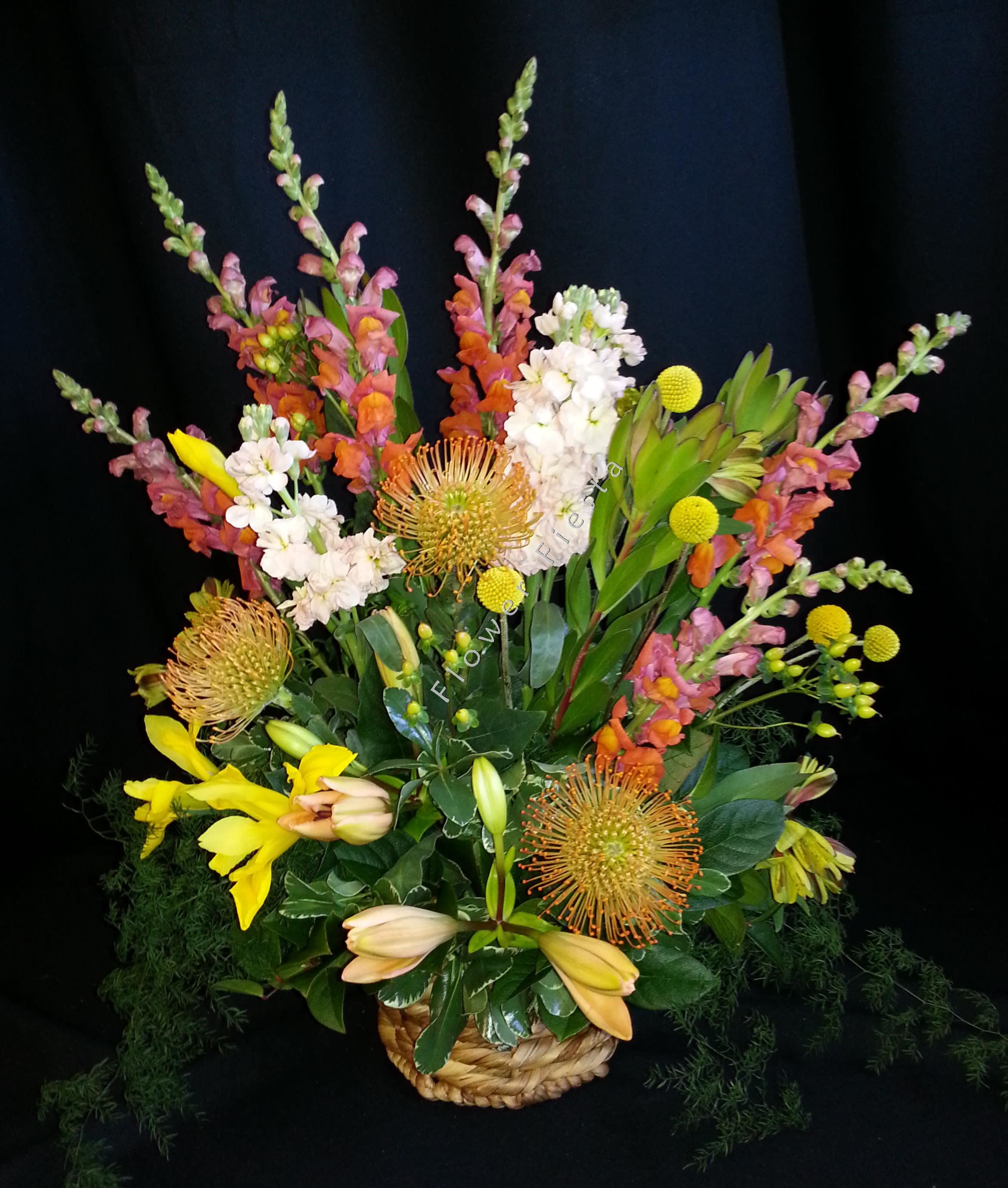 Australian style basket mix - Long lasting mix  - Flowers and colors will vary. Container will vary.  Fun for a man's birthday or a summer reception.  One sided design of flowers in floral foam in a basket.